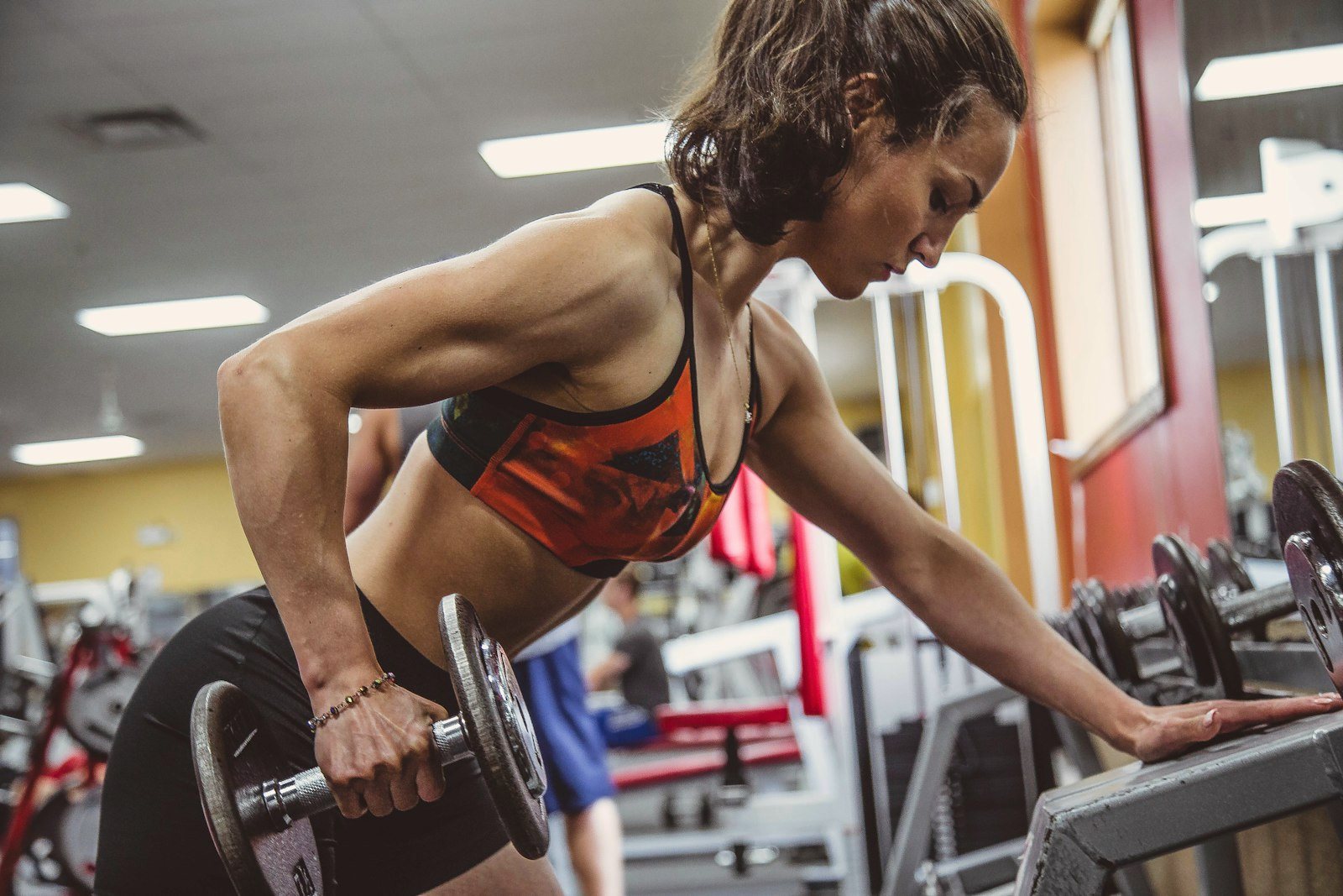 Woman training with a dumbbell in a gym